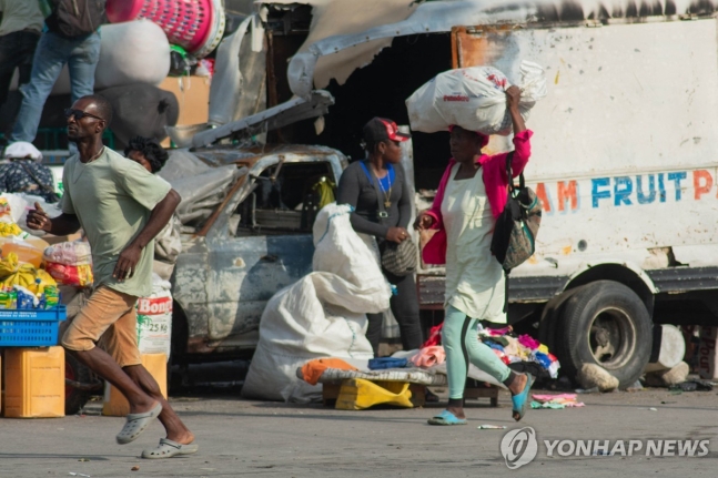 황급히 대피하는 아이티 주민들 (포르토프랭스 AFP=연합뉴스) 13일(현지시간) 아이티 포르토프랭스에서 주민들이 총격 소리를 듣고 대피하고 있다. 2024.4.14