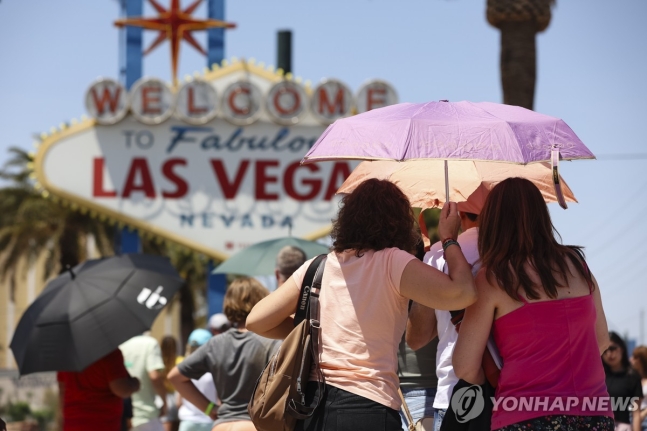 지난 8일(현지시간) 라스베이거스에서 양산으로 햇볕을 가리는 사람들 [Wade Vandervort/Las Vegas Sun/AP 연합뉴스 자료사진. 재판매 및 DB 금지]