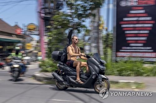 발리 관광객 발리를 찾은 한 관광객이 상의를 탈의한 채 헬멧도 없이 오토바이를 타고 있다. [EPA 연합뉴스 자료사진. 재판매 및 DB 금지]