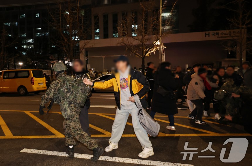 윤석열 대통령이 비상계엄령을 전격 선포한 가운데 4일 새벽 서울 여의도 국회 앞에서 시민들이 경내로 진입하려는 계엄군을 붙잡아 막아서고 있다. 2024.12.4/뉴스1 ⓒ News1 구윤성 기자