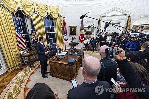 백악관 집무실에서 취재진과 질의응답하며 행정명령에 서명하는 트럼프 [워싱턴 EPA=연합뉴스. 재판매 및 DB 금지]